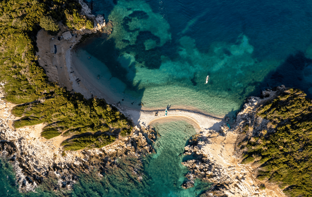  Aerial view of pristine Albania beach with turquoise waters and rocky coastline during Albania summer