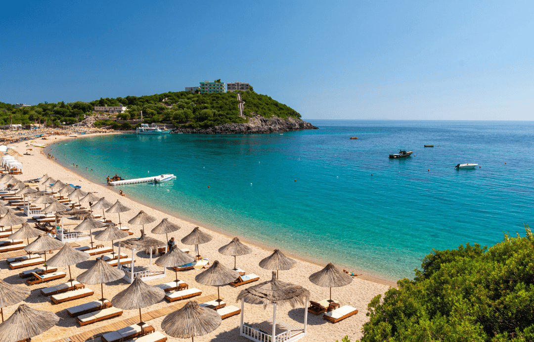 Ksamil beach in Albania summer with sun loungers, umbrellas, and crystal-clear Ionian Sea