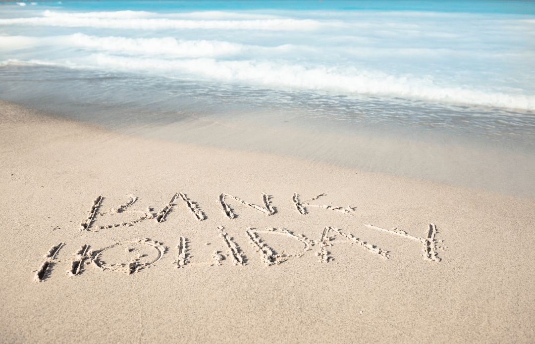 bank holiday written on the sand by the sea