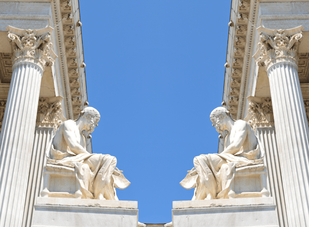 Philosopher statues at the Academy of Athens under clear blue sky – classical Greek architecture